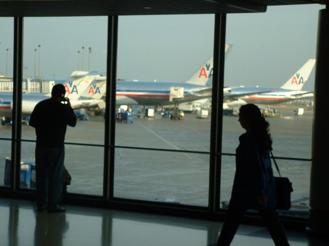 lidé čekající na své lety v čekací hale na letišti